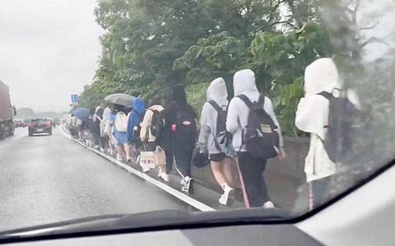 國道驚見「學生排隊淋雨走路」！30多人背書包走路肩 真相曝光