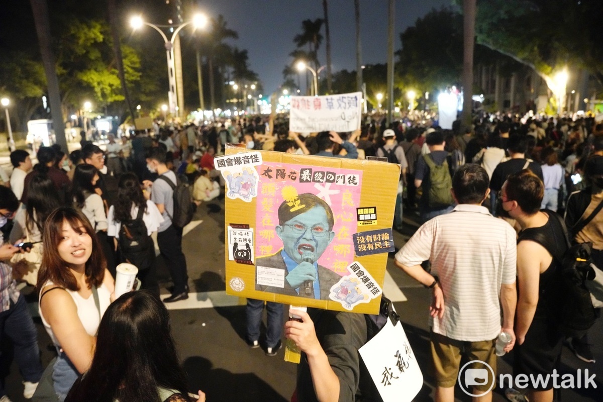 一位民眾在人群中高群嘲諷民眾黨立委黃國昌的手舉牌。 圖：張良一／攝（資料照）