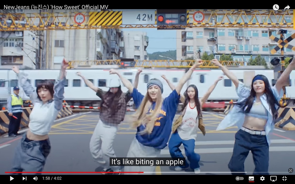 NewJeans新歌〈HOW SWEET〉來台拍攝取景，其中一幕是NewJeans的5位成員站在鐵路平交道前面跳舞，許多粉絲會到拍攝地踩點。 圖：翻攝自HYBE LABELS YT頻道