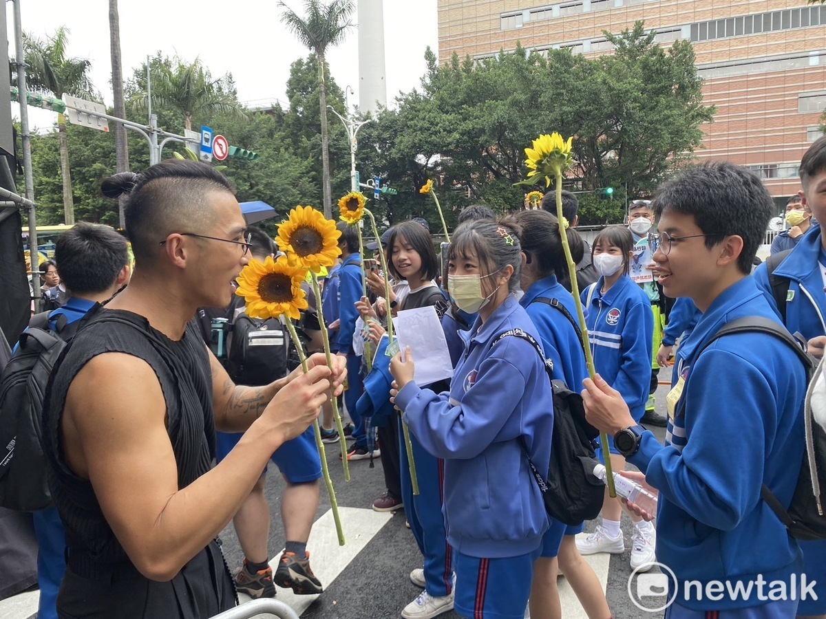 林先生發送免費太陽花給今天到場參加集會的同學們。 圖：林昀真/攝