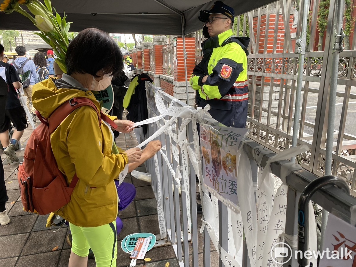 民眾將寫好抗議國會濫權的白布條綁在立院周邊的欄杆上。 圖：林昀真/攝