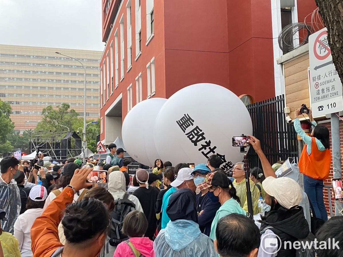 萬名集結民眾共同將寫著「公民捍衛民主、重啟社會對話」的大球滾進立法院，要將人民的聲音傳進立院。 圖：林昀真/攝