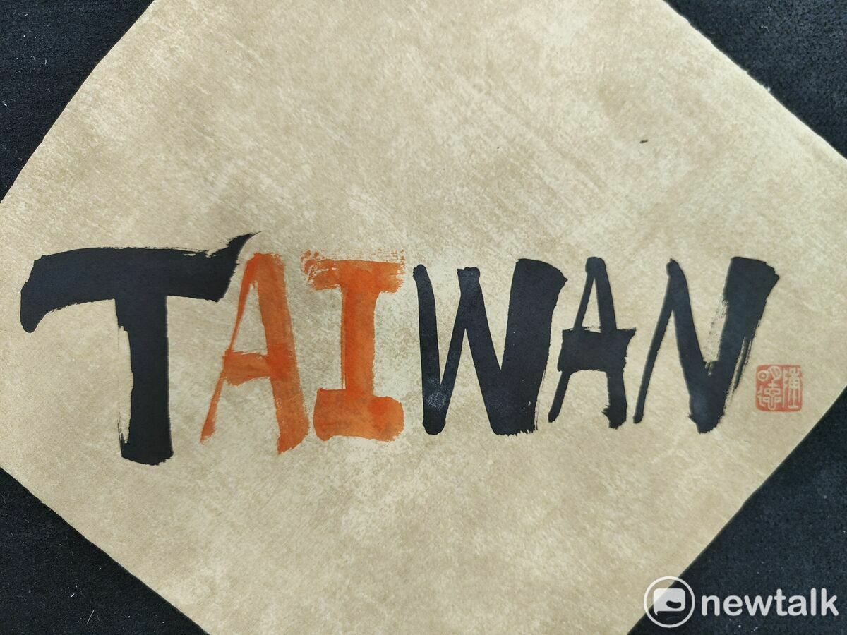 書法家陳明德發現台灣的英文TAIWAN似乎早已暗藏密碼，中間恰巧夾著「AI」兩字，遂用毛筆蘸墨援筆一揮，其中AI用朱液書寫，凸顯AI的視覺感與重要性，其創意和蒼勁筆力，見者無不驚嘆。 圖：黃博郎／攝