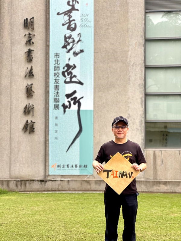 書法家陳明德發現台灣的英文TAIWAN似乎早已暗藏密碼，中間恰巧夾著「AI」兩字，遂用毛筆蘸墨援筆一揮，其中AI用朱液書寫，凸顯AI的視覺感與重要性，其創意和蒼勁筆力，見者無不驚嘆。 圖：黃博郎／攝