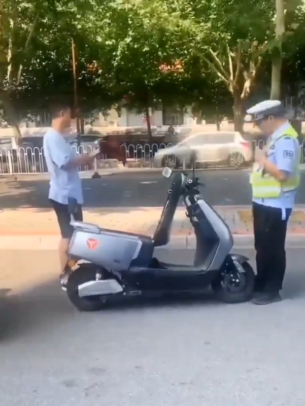 警察企圖沒收男子電動車時，男子直接從電動車後座拿出摺疊傘並攻擊警察。 圖：翻攝自 Daniel Fang X（前推特）帳號