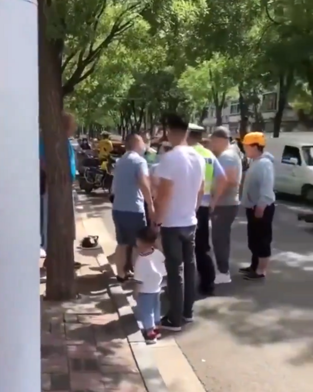 警察查禁電動車時，當著孩子的面肆意毆打其母親。路過的民眾被警察蠻橫舉止觸怒，一同將警察包圍。 圖：翻攝自海外爆料 X（前推特）帳號