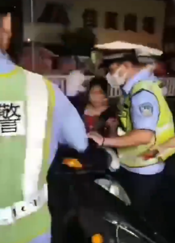 女子被警察沒收電動車時圖反抗，最終被警察架走。 圖：翻攝自新聞調查 X（前推特）帳號