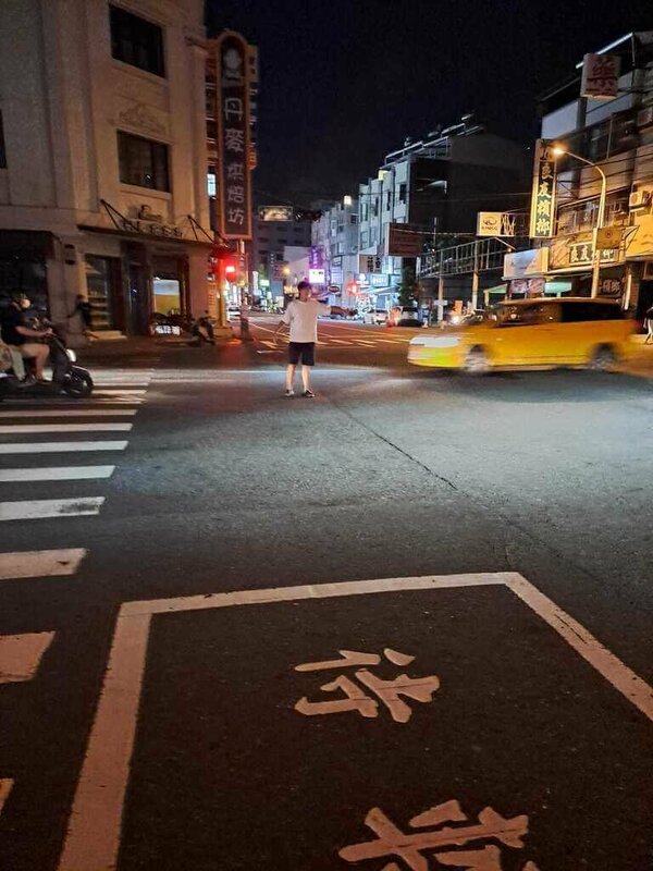 屏東縣屏東市中心廣東路、中山路等路段19日晚間7點多突然停電，部分路口交通號誌也斷電停擺，有熱心年輕人打開手機燈光協助指揮交通。 圖：屏東市崇蘭里長賴榮彬提供