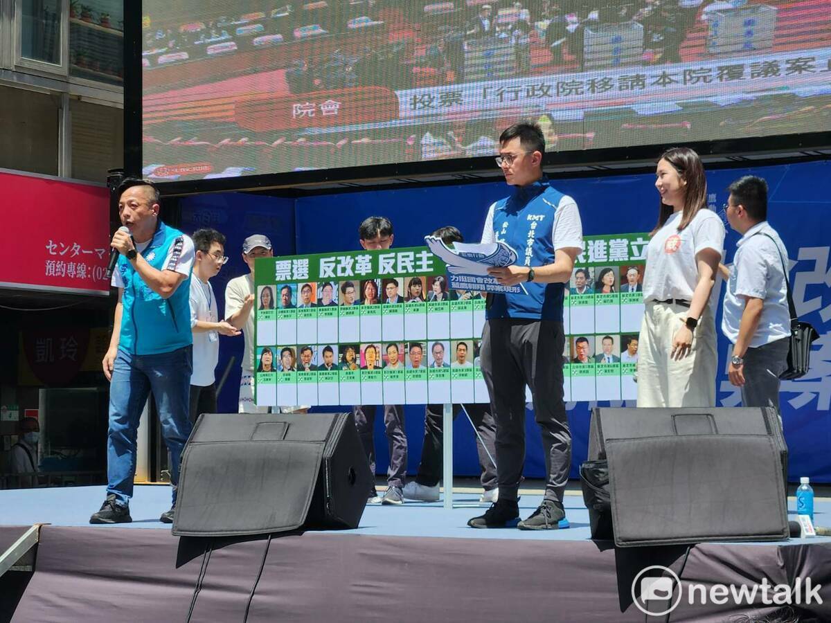 國民黨在台上秀出「最應該罷免民進黨立委」圖卡，喊話罷免民進黨立委作為反擊。 圖：黃建豪/攝