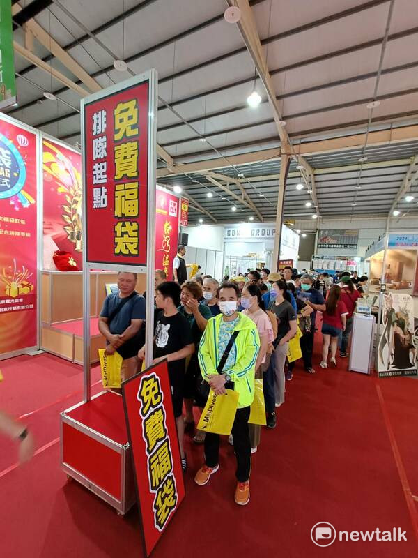 旅展會場有免費送福袋活動，吸引民眾排隊。 圖：唐復年/攝