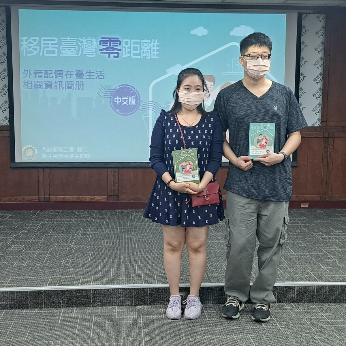 越南籍新住民許女士(圖左)與先生各持中文版及越南語版「新住民在臺生活相關資訊簡冊」合影。 圖：移民署提供