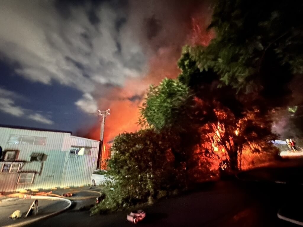 新北市五股區民義路某鐵皮工廠30日晚間發生火警，警消獲報派出大批人車到場，布水線灌救，初估燃燒面積約500坪。 圖：警消提供