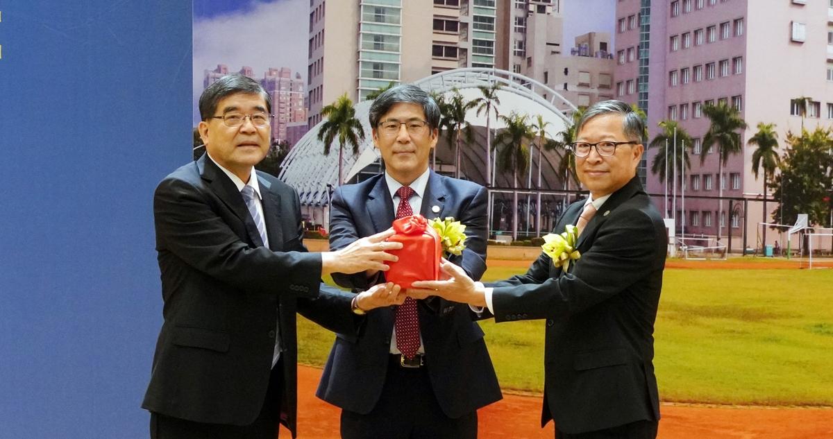 在陳建志(中)監交下，楊俊毓(左)將印信交接給余明隆(右)。 圖：高雄醫學大學/提供