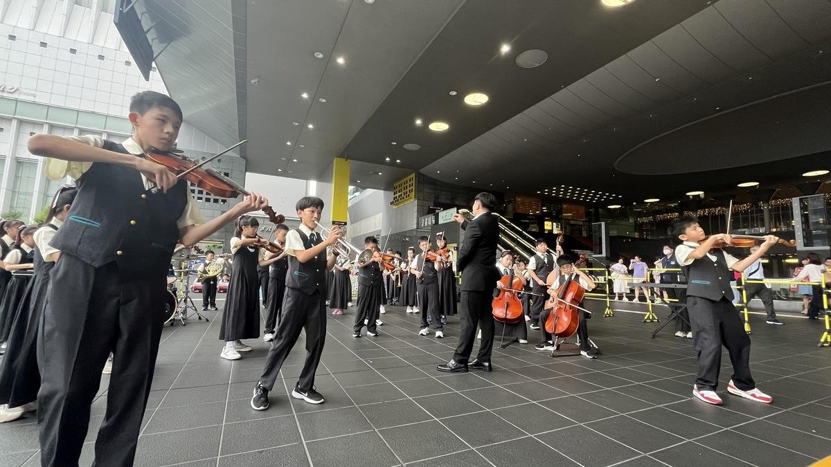 「2024樂上國際日本京都音樂交流」由桃園市大竹及文欣國小樂團在京都JR車站進行快閃演出。 圖：吳俊生/提供