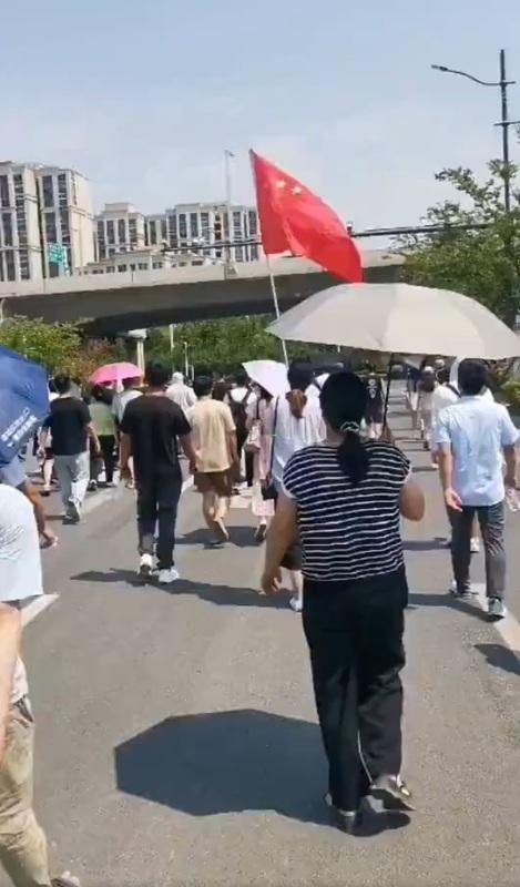 河南鄭州的新城時光印象樓盤延期交房，業主頂著高溫手舉國旗遊行維權。 圖：翻攝自李老師不是你老師 X（前推特）帳號