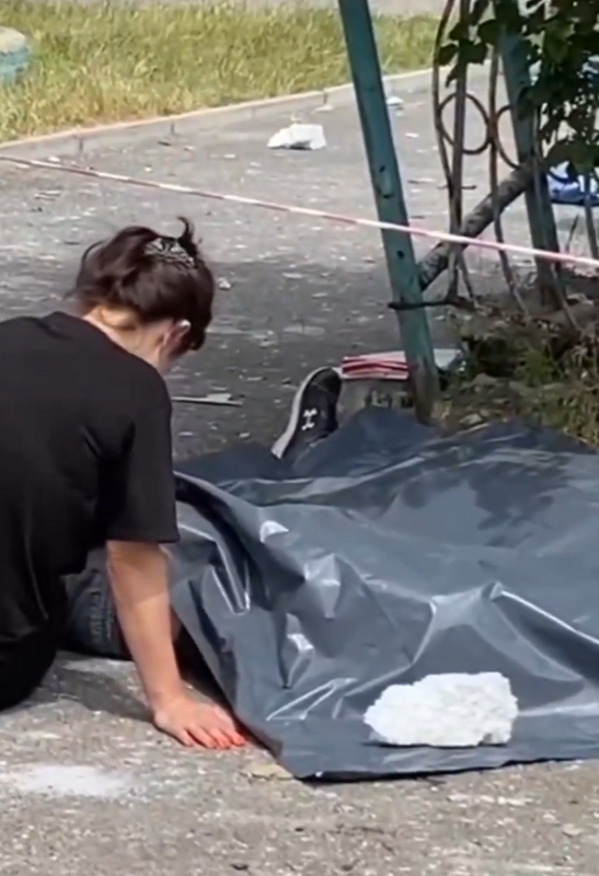 基輔受到俄羅斯襲擊，一名女子坐在一具遺體旁哭泣。 圖：翻攝自格拉先科 X（前推特）帳號