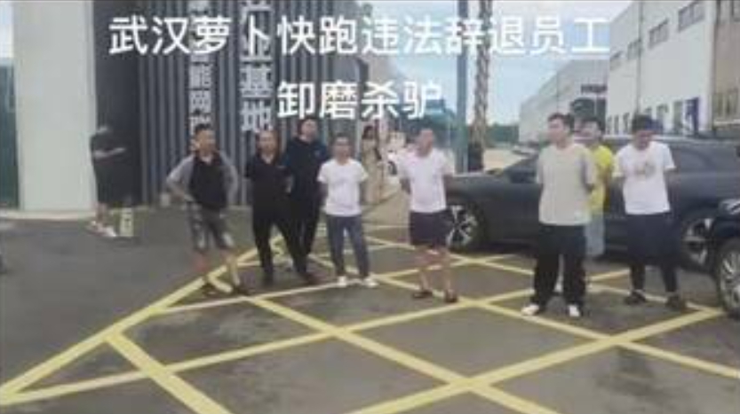 在武漢市區，遭到裁員的「蘿蔔快跑」司機站成一排，憤慨地吶喊被公司解雇無奈的心情 圖 : 翻攝自 X / 李老師不是你老師