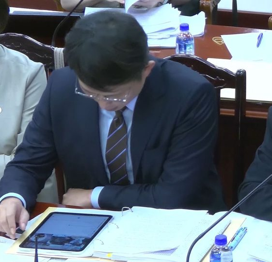 黃國昌被發現在憲法法庭看自己的直播留言。 圖：翻攝畫面