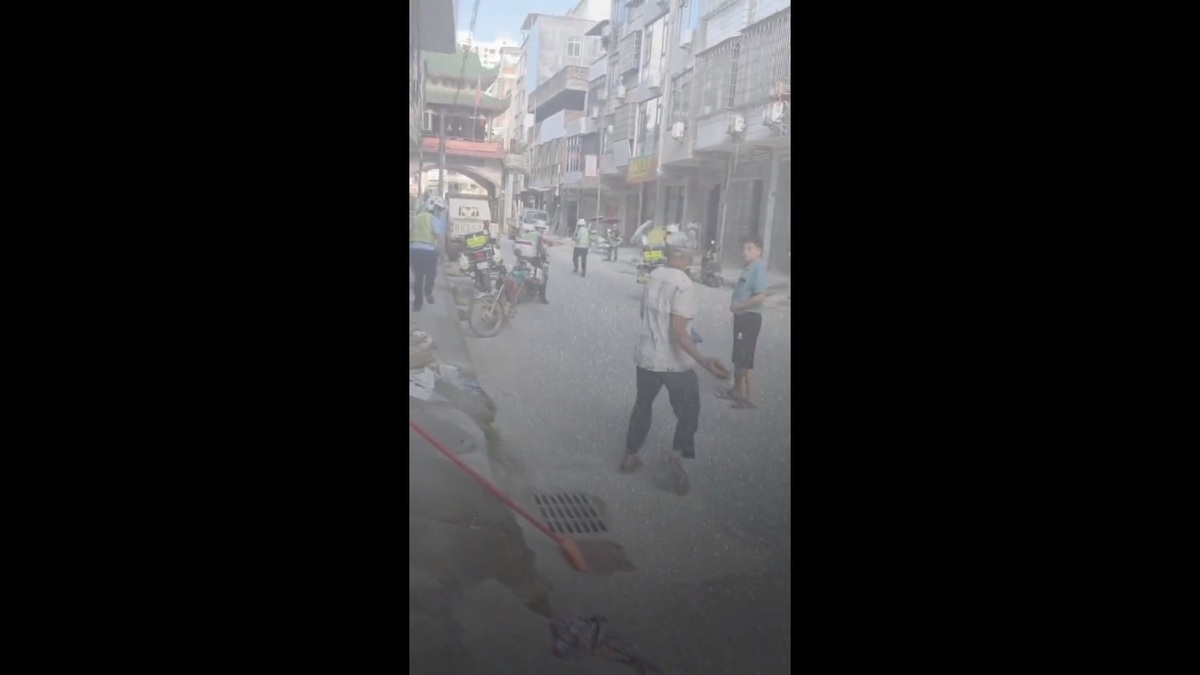 為了防止自己的摩托車被交通警察沒收，廣東省一名男子直接抄起路邊的磚頭，嚇的交警們立刻轉身逃離。 圖：擷取自 @whyyoutouzhele X 分享影片