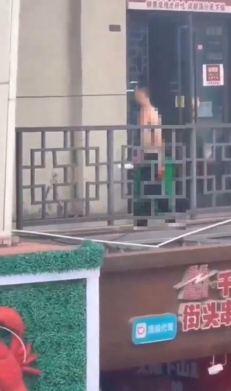 一男子手持在杭州拱墅區萬達廣場陽台上走動，且身上還有血跡。 圖：翻攝自德潤傳媒 X（前推特）帳號