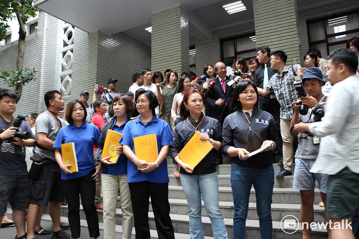國民黨立委也拿著「前瞻基礎建設計畫第一期預算」黃皮書來到鎮江街側門守候。 圖：廖品瑄／攝