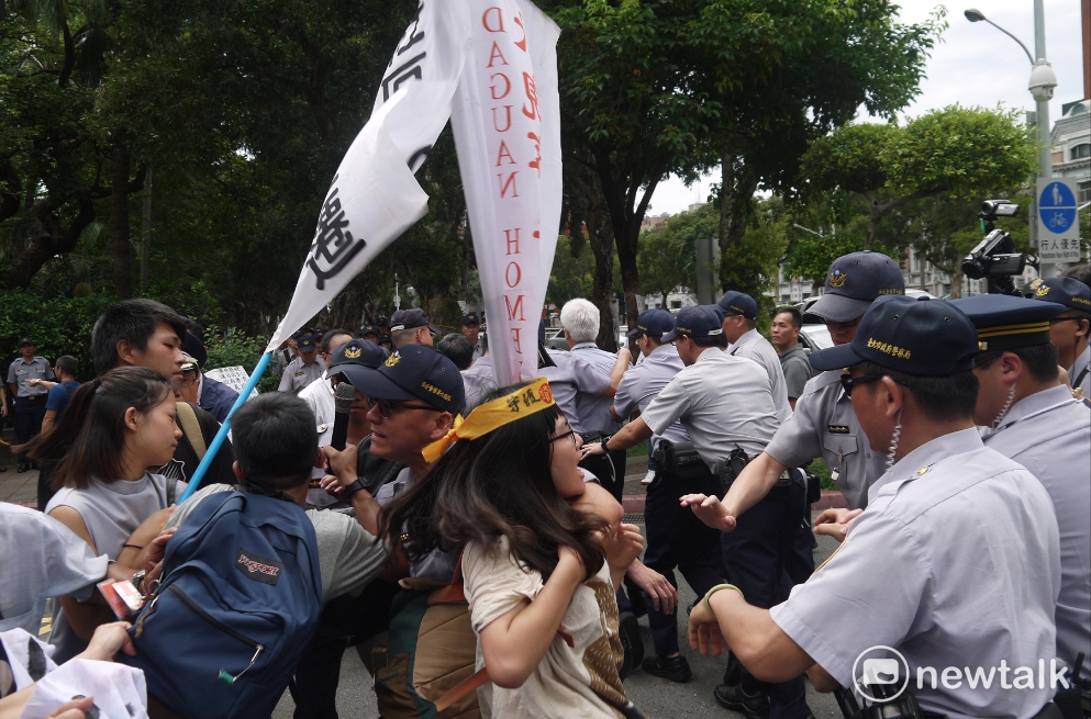 張洪鈞離去時，大觀事件自救會成員上前企圖阻擋，大批警方阻止成員向前。 圖：鍾孟軒/攝