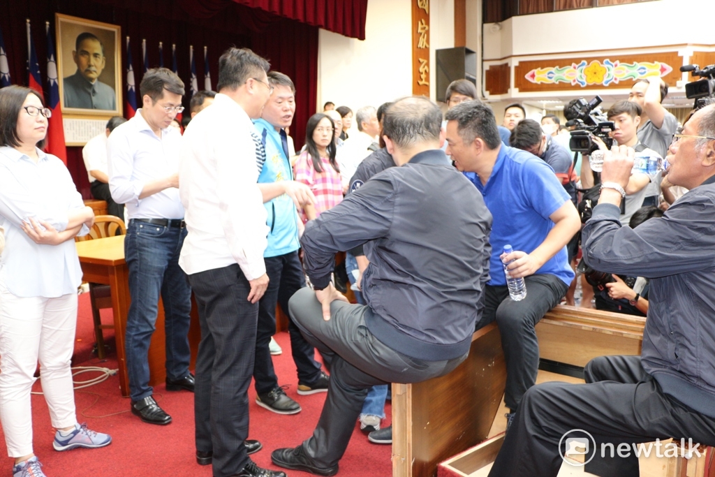 國民黨政策會執行長林德福等人在衝突過後，乾脆坐在發言台上，聯席會儼然成為武鬥場。 圖：廖品瑄 / 攝