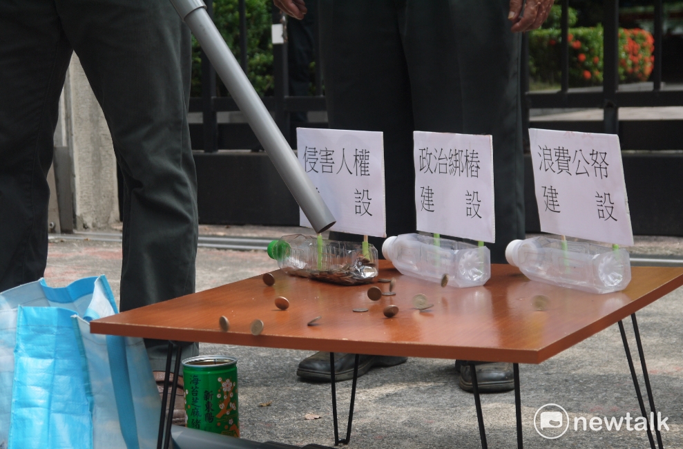 自救會居民演起行動劇，象徵拓寬道路的經費都拿去綁樁、迫遷居民與浪費公帑。 圖：鍾孟軒/攝