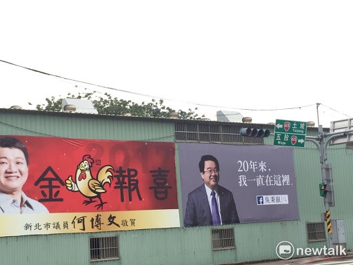 新北市議員何博文的看板，剛好在吳秉叡的廣告"二十年來，我一直在這裡"旁邊，頗堪玩味。 圖:新頭殼資料照片