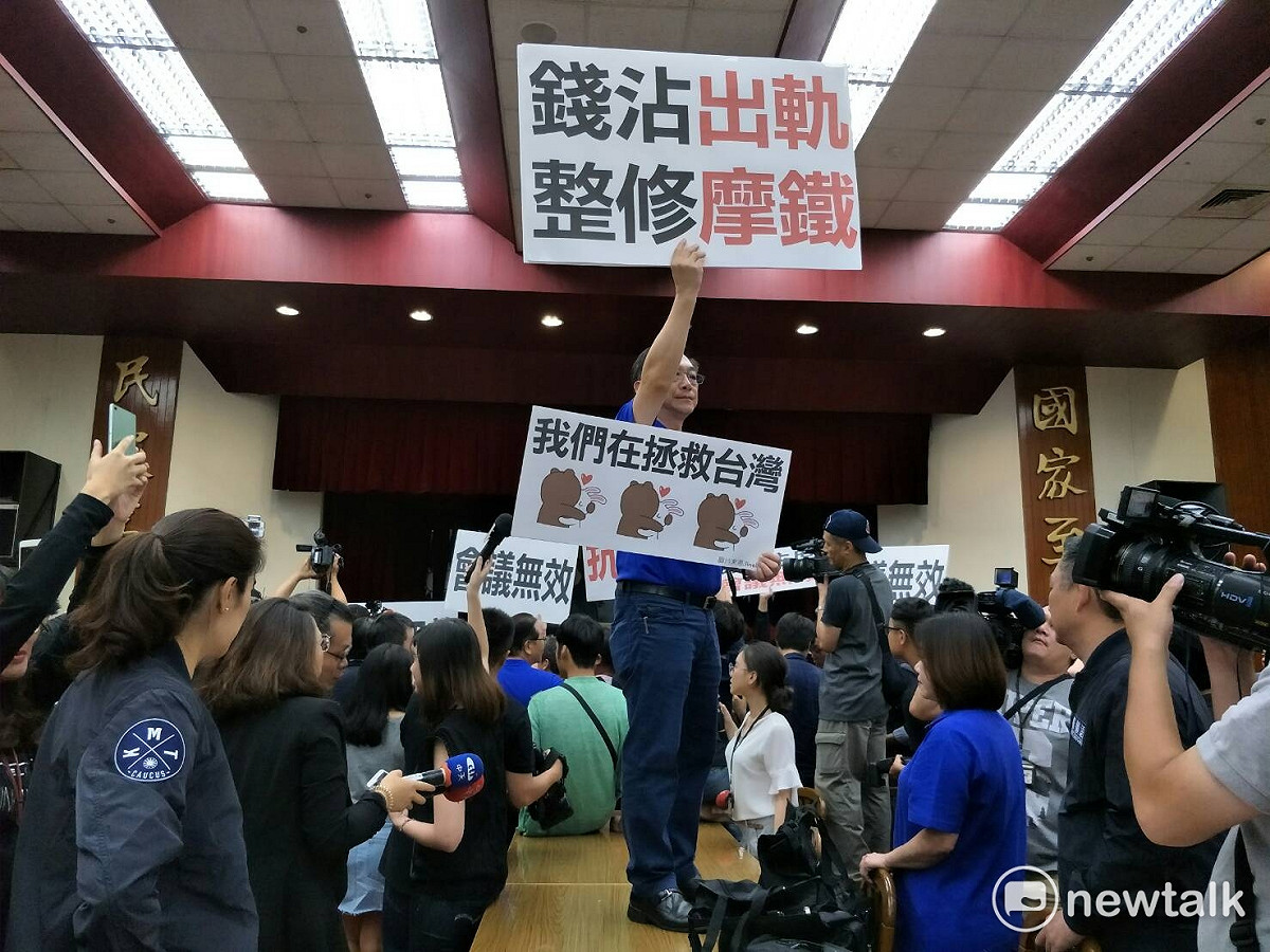 國民黨立院黨團19日在前瞻特別預算委員會審查時，高舉「錢沾出軌，整修摩鐵」標語，諷刺羅致政的桃色風波。 圖：林人芳／攝
