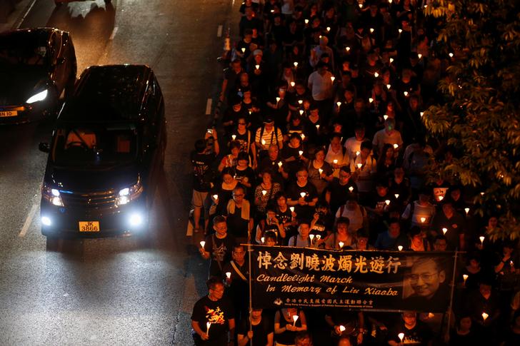 香港民眾冒著雨，以燭光遊行的方式，悼念諾貝爾和平獎得主劉曉波。 圖：達志影像／路透社