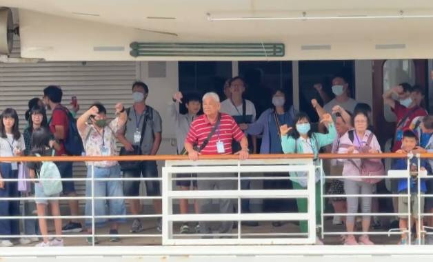 歌詩達郵輪莎倫娜號旅客以手勢表達心中不滿。 圖：孫家銘翻攝
