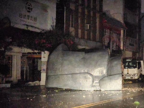花蓮軒轅路上一處咖啡店樓頂的裝置藝術「巨型摩艾像」遭強風吹斷，躺倒馬路中央。 圖：翻攝自記者爆料網