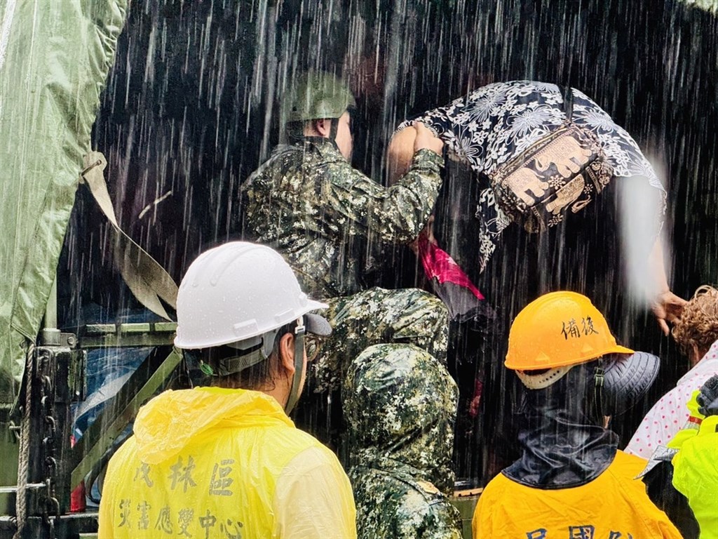 高雄市山區8個行政區共106條土石流黃色警戒及7處大崩塌警戒黃色警戒，市府啟動預防性撤離，2000多名居民24日冒雨登上軍用卡車前往安置場所。 圖：高雄市政府原住民事務委員會提供
