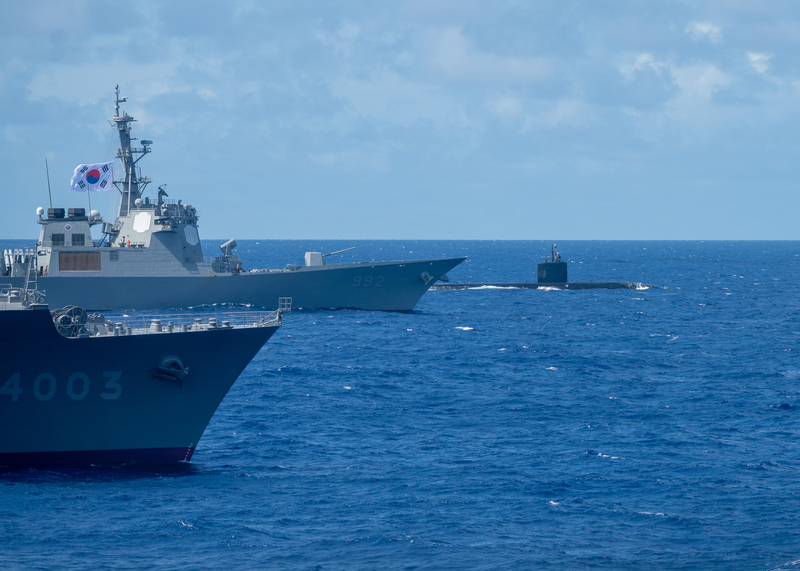 2024年環太平洋軍演（RIMPAC）近40艘軍艦在海上編隊航行，展示各國「作業互通能力」（interoperability），即不同國家裝備和系統可共同進行任務。圖為日本海上自衛隊的兩棲運輸艦國東號（LST-4003）（前）、韓國海軍飛彈驅逐艦栗谷李珥號（DDG-992）（中）、美國潛艦北卡羅萊納號（SSN-777）（後）。 圖：中央社/DVIDS提供