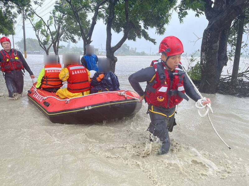受颱風凱米影響，嘉義縣豪雨強風不減，25日雨勢持續且逢大潮，八掌溪水暴漲溢堤，消防人員協助民眾脫困。 圖：嘉義縣消防局提供
