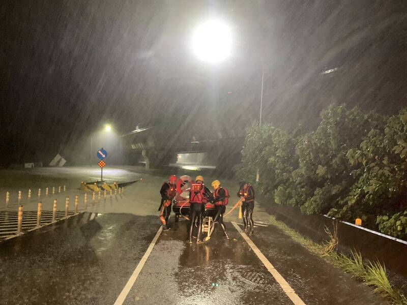 凱米颱風為嘉義縣帶來大雨，八掌溪水暴漲溢堤，民眾受困於台82線中和交流道，嘉義縣消防局25日清晨派員協助脫困。 圖：中央社/嘉義縣消防局提供