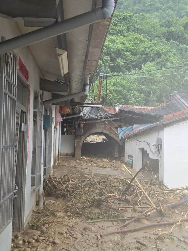 高雄市旗山區一間民宅25日下午遭土石流沖入，屋內78歲李姓屋主及79歲呂姓妻子遭土石掩埋，呂姓女子被救出時意識清楚送醫救治，李姓男子全身遭埋死亡。 圖：高雄市政府警察局旗山分局提供