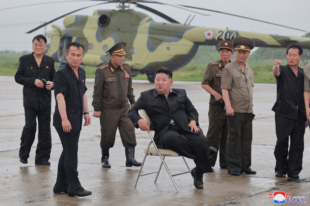 北韓領導人金正恩視察平安北道洪災，軍用直升機協助疏運災民現場，竟需要椅子坐下休息。 圖 : 朝中社