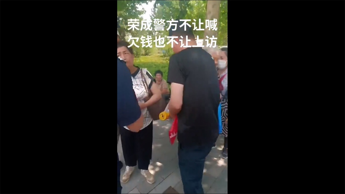 山東省榮成市的盛泉集團吸附大量民眾資金後宣布暴雷，民眾前往榮成市政府試圖維權卻遭到警方鎮壓，甚至有警察搶奪維權民眾的布條。 圖：擷取自 @whyyoutouzhele X 分享影片