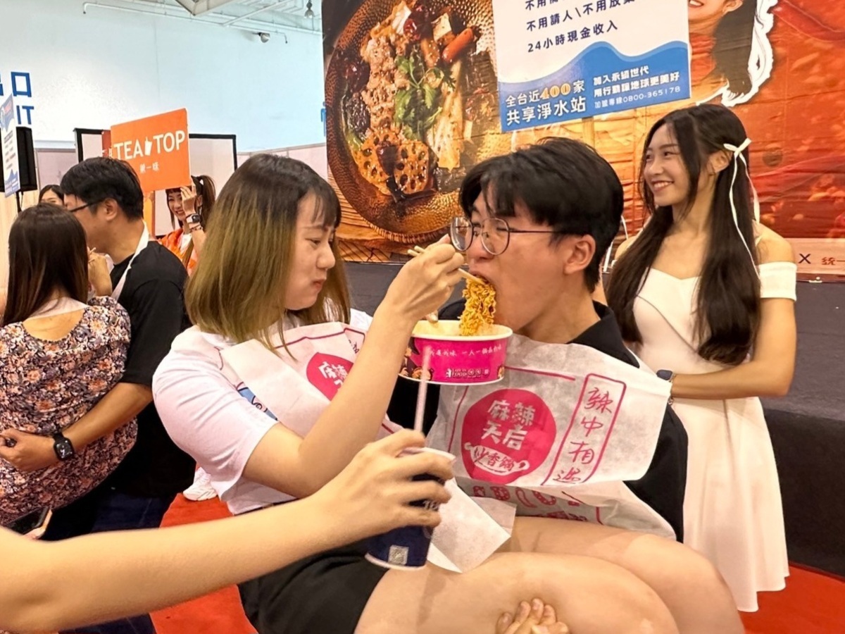 參賽情侶一邊公主抱，一邊吃麻辣香鍋。 圖：台灣連鎖加盟促進協會/提供
