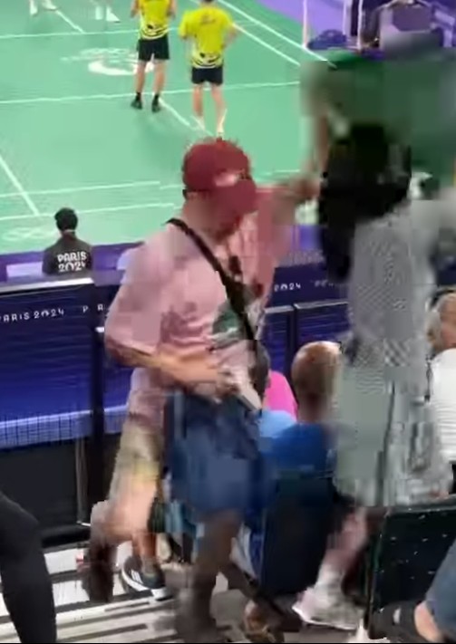 台灣女球迷手拿台灣地圖造型加油海報替「麟洋配」加油，一名小粉紅上前一把扯下並奪走海報。 圖：翻攝曹興誠臉書