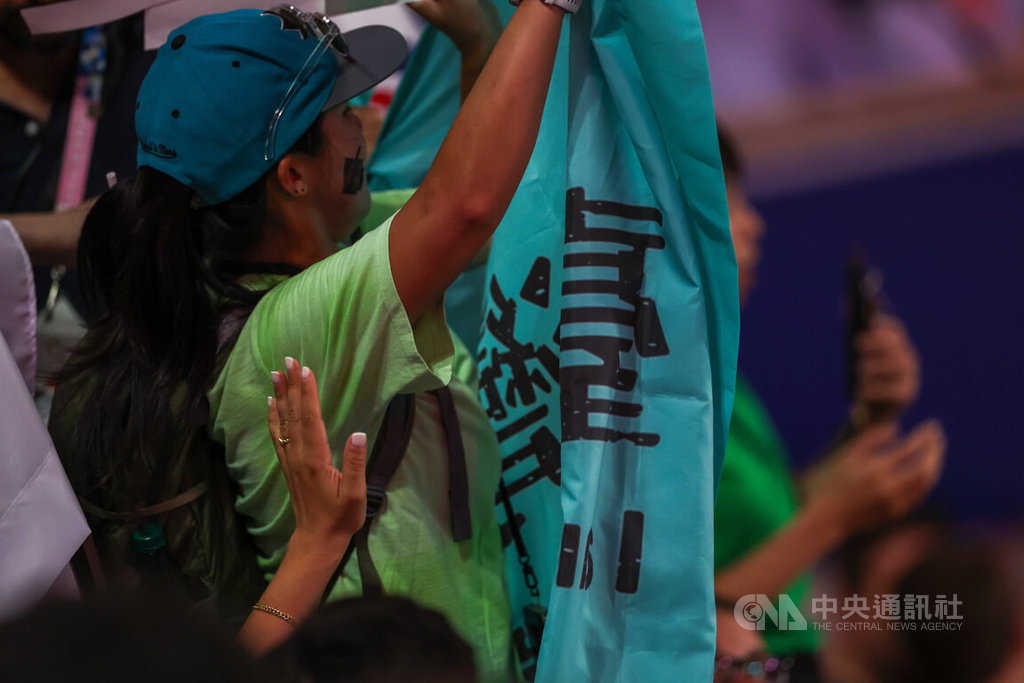 巴黎奧運女子拳擊57公斤級金牌戰場邊有民眾自備一幅寫有「台灣」、「獨立」等字句的旗幟到場要為台灣選手加油，現場工作人員發現後上前關切溝通。 圖/中央社