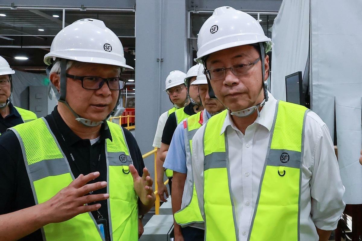 台灣順豐總經理潘逸俊向張善政說明全自動化分揀設備運作模式，大幅提升貨件轉運效率。 圖：台灣順豐/提供