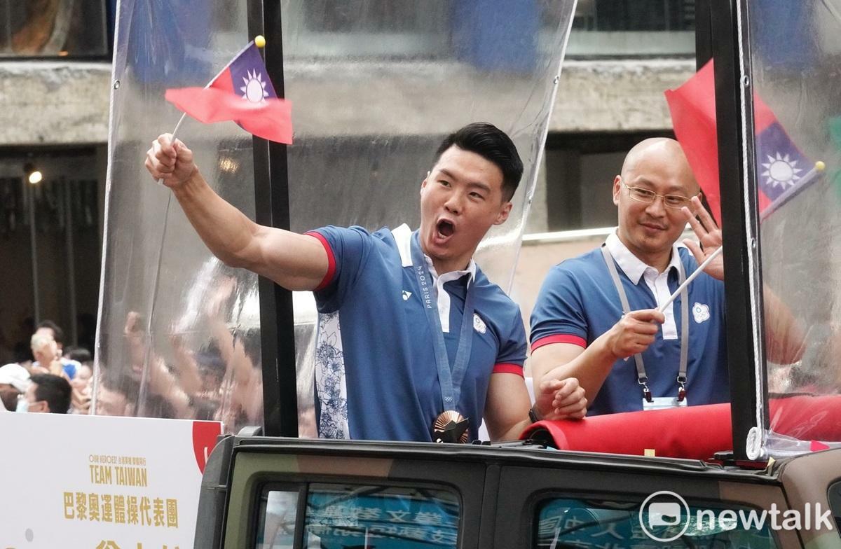 巴黎奧運體操銅牌選手唐嘉鴻站在吉普車上向民眾揮手致意。 圖：張良一/攝