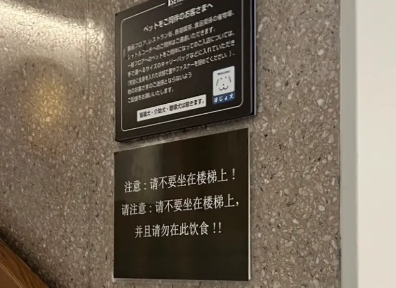 ▲位於日本新宿的百貨公司，在樓梯間貼出「簡體字公告」，疑似特別針對中國遊客提醒不要坐在樓梯上飲食。 圖／翻攝社群平台X