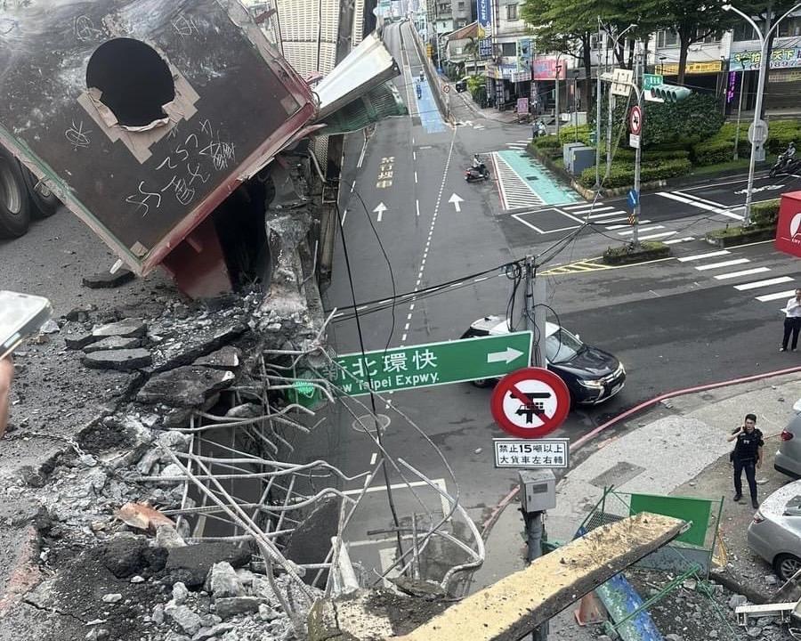 大型拖板車上鋼柱滑落，砸破護欄。 圖：新北市政府/提供