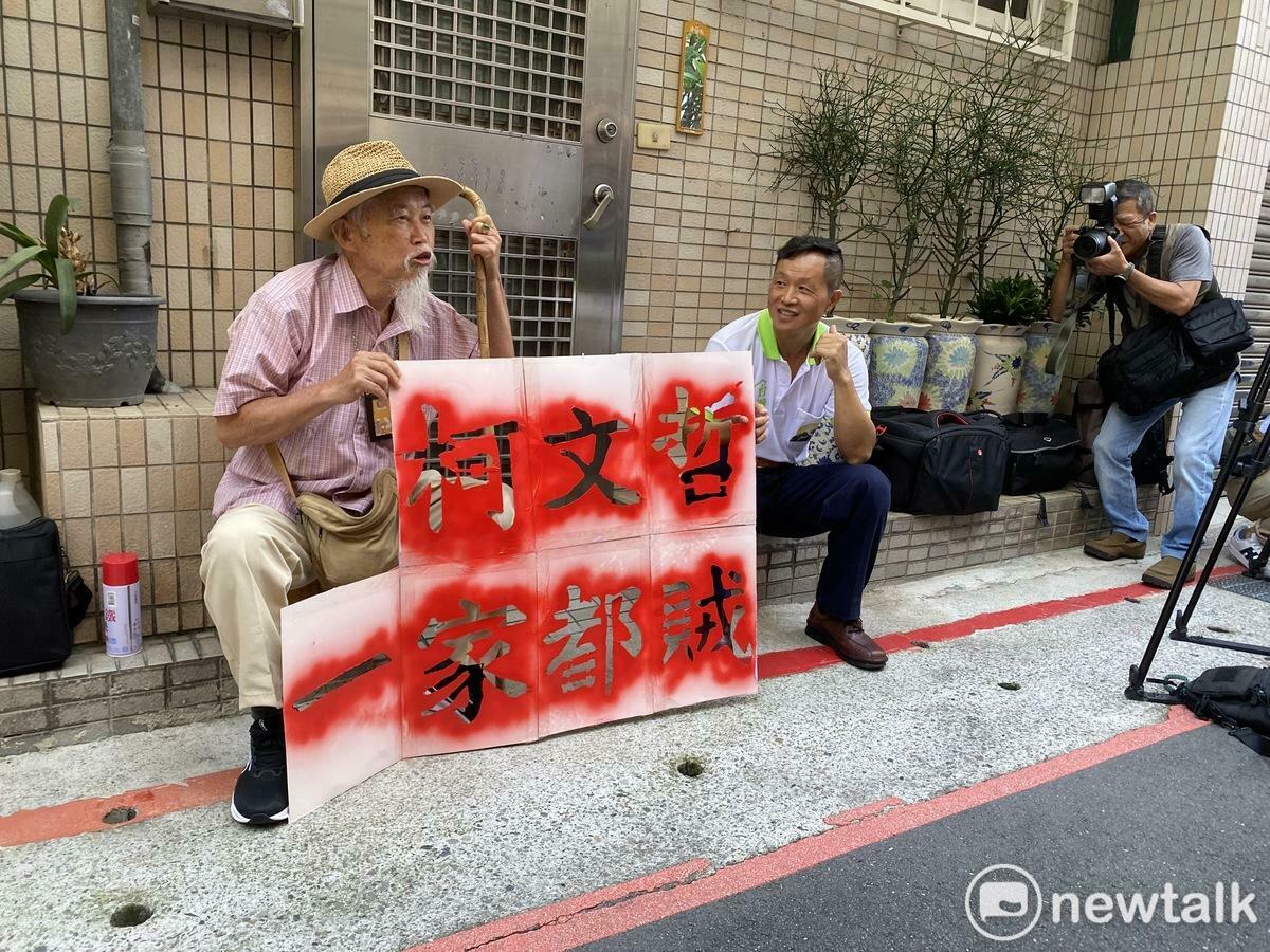 「台灣國」創辦人王獻極（左）、理事長陳峻涵噴漆抗議民眾黨主席柯文哲。 圖：周煊惠 / 攝