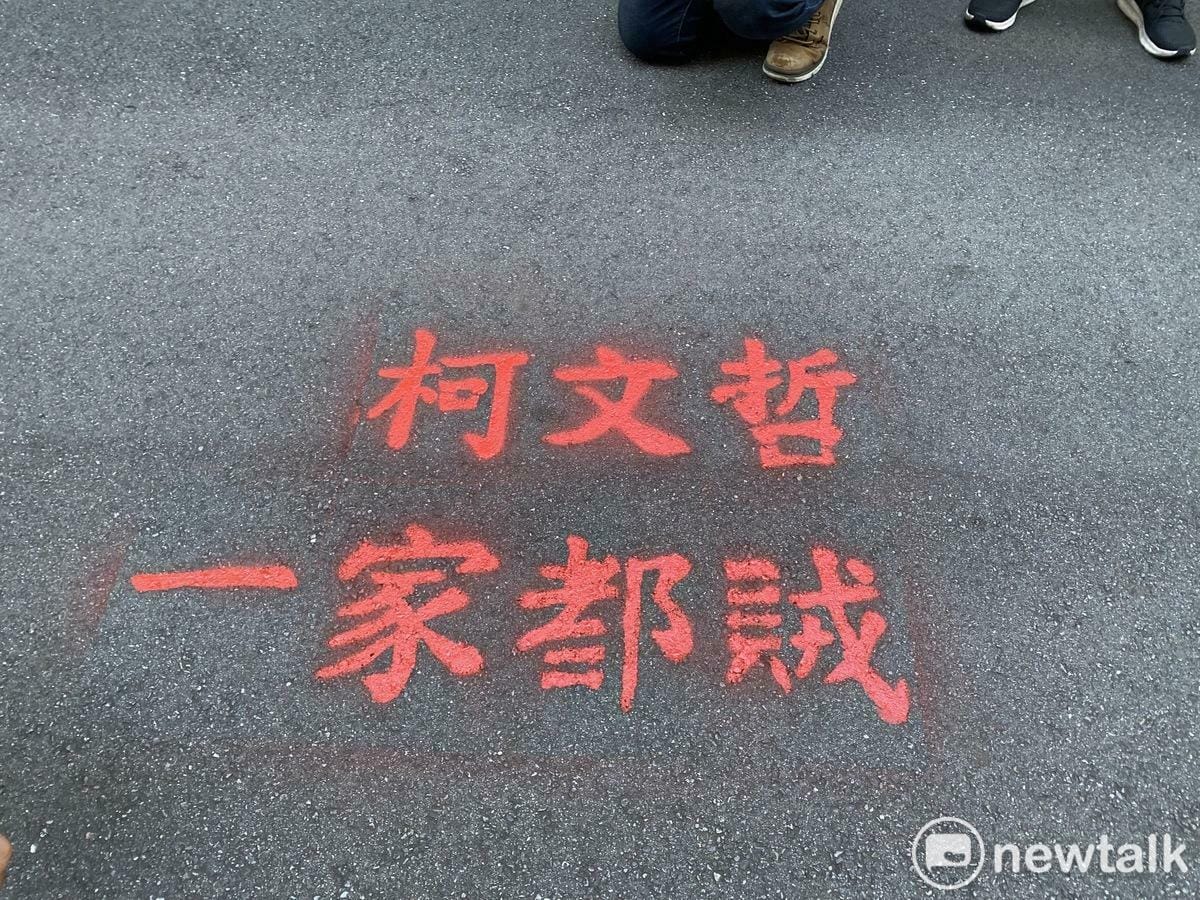 「台灣國」創辦人王獻極（左）、理事長陳峻涵噴漆抗議民眾黨主席柯文哲。 圖：周煊惠 / 攝