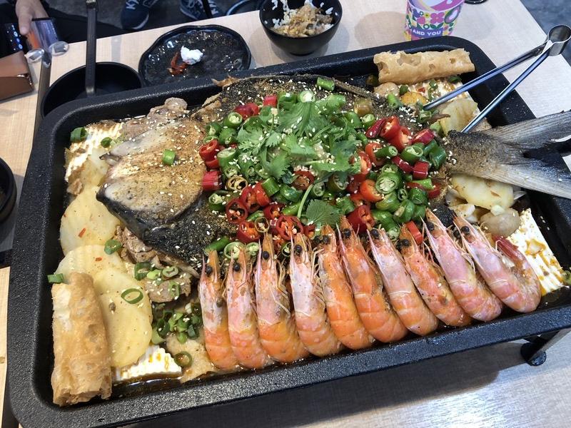 烤魚料理源自四川成都，而成都古稱「蓉城」，所以四川成都烤魚又被稱為「蓉城烤魚」，消費者還可以加選大蝦，更加美味豐盛。 圖：黃博郎／攝